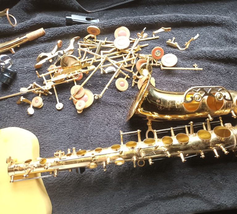 All the parts of a saxophone in a heap